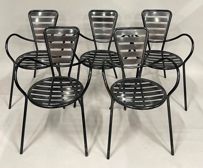 quatre chaises en métal noir posées sur une surface blanche