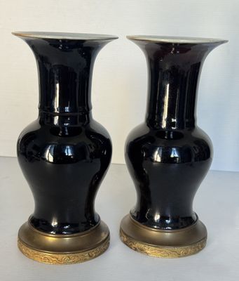 deux vases noirs posés sur une table blanche