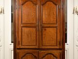 a large wooden armoire in the middle of a room