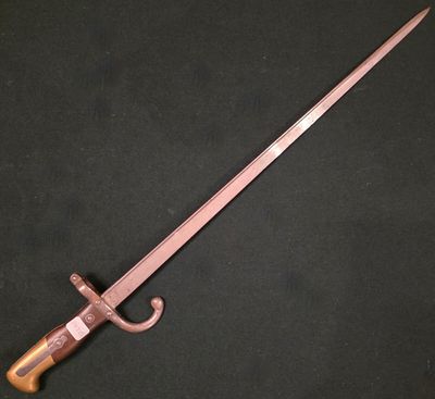 une vieille épée avec une poignée en bois sur fond noir