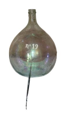 un vase en verre d'où sort un bâton