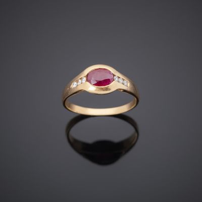 a gold ring with a ruby stone and diamonds