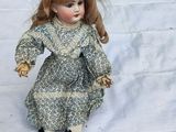 a small doll that is sitting on a white sheet