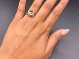 a woman ' s hand with a yellow and white ring on it