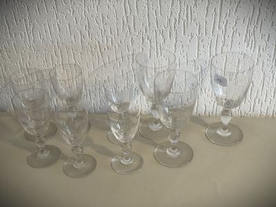 plusieurs verres à vin vides posés sur une table près d'un mur