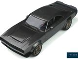 a black toy car that is sitting on a white surface