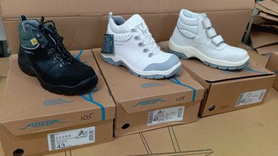 Trois paires de chaussures pour enfants se trouvent dans une boîte en carton.