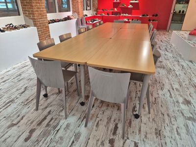 tables and chairs in a room with a red wall and a wooden floor
