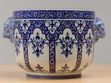 a large blue and white vase with a lion head on it