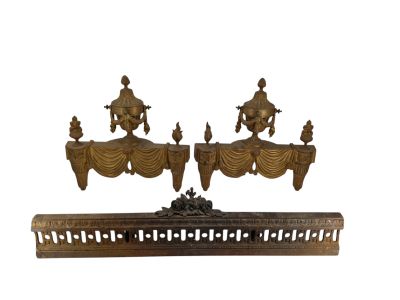 une paire de lits anciens en bois sculpté, avec des draperies et des rideaux dorés
