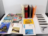 beaucoup de livres posés sur une table sur laquelle se trouve un pistolet