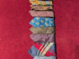 many ties laid out on a red carpet