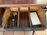 a wooden drawer with utensils and knives inside of it