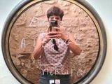 a woman taking a picture of herself in a mirror
