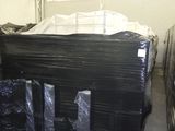 une grande pile de sacs en plastique noirs dans un entrepôt