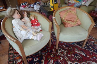 deux chaises sur lesquelles sont assises des poupées, dans un salon
