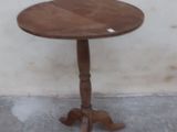 a small table with a wooden top on a concrete floor