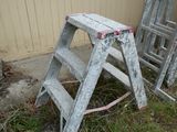two ladders that are sitting in the grass