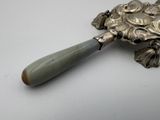 a silver spoon with a handle on a white table