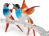 two birds sitting on a branch with a spoon