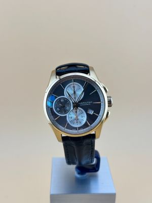 la montre est posée sur un support, sur une surface blanche