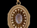 un gros plan sur une boucle d'oreille en or ornée d'un améthyste et de perles