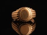 gros plan d'une bague en or sur une surface noire