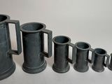 un ensemble de vases noirs disposés les uns à côté des autres sur une table