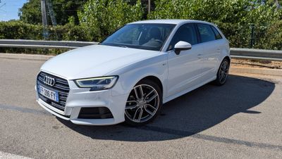 L'Audi blanche est garée sur le bord de la route.