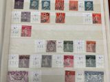 un livre ouvert sur lequel figure l'image d'une collection de timbres