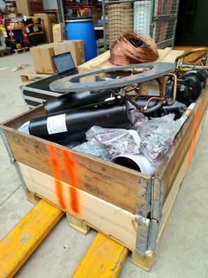 une caisse en bois remplie d'articles divers, posée sur une palette