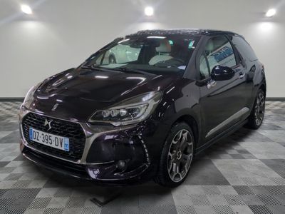 la voiture noire est garée sur un sol en damier dans le garage