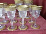 many wine glasses sitting on a table with gold rims