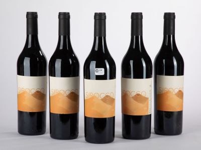 quatre bouteilles de vin sont alignées sur une surface blanche