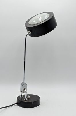 un gros plan d'une lampe noire posée sur une surface blanche