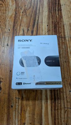 La boîte du chargeur sans fil Sony se trouve sur le parquet.