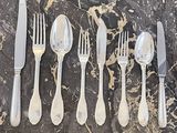cinq fourchettes, deux couteaux et une cuillère sur une table