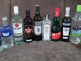 de nombreuses bouteilles d'alcool de toutes sortes alignées sur une chaise