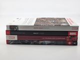 three books are stacked on top of each other on a table