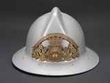 a white fireman ' s helmet with a gold emblem on it