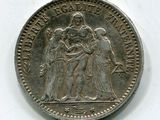 une vieille pièce d'argent sur laquelle figure l'image d'un groupe de personnes