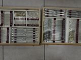 many forks and spoons in a wooden box on the wall