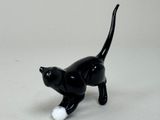 a black cat with a white ball in it ' s mouth