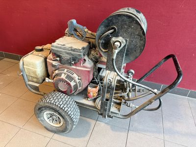 une machine posée par terre devant un mur rouge