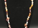 un collier composé de perles multicolores sur un mannequin noir