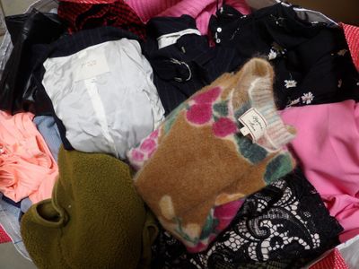 a suitcase full of clothes and a teddy bear inside of it