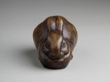 a close up of a small animal figurine on a white surface