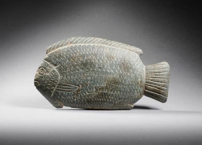 an image of a stone figurine of a fish on a gray background