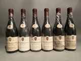 six bottles of wine are lined up in a row on a table
