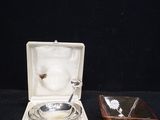 a small silver plate and a glass bowl on a black table